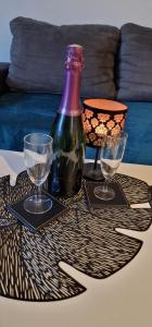 a table with two wine glasses and a bottle on it at Étoiles et Désirs in Kermaria-Sulard