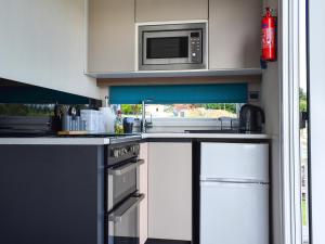 a kitchen with a stove and a microwave at Valley View - Uk50320 in Liskeard