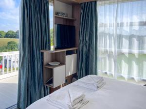 a bedroom with a bed with a tv and a window at Valley View - Uk50320 in Liskeard +7 photos