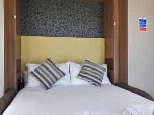 a bed with two black and white pillows on it at Valley View - Uk50320 in Liskeard
