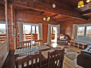 a living room with a table and chairs in a cabin at White Springs - Lake View in Llanedy