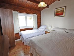 a bedroom with two beds and a window at White Springs - Lake View in Llanedy