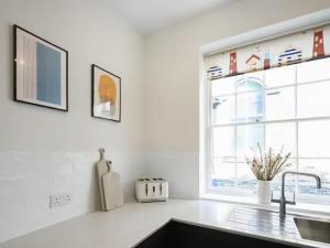 a kitchen with a sink and a window at Surf Cottage in Cromer