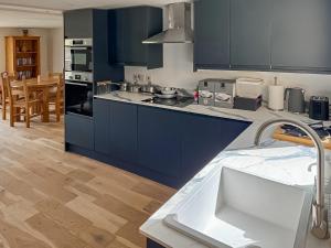 a kitchen with blue cabinets and a kitchen sink at Fernhill Stables in Sevenoaks