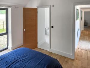 a bedroom with a bed and a sliding door at Fernhill Stables in Sevenoaks