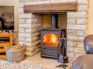 a wood burning stove in a living room at Shepherd's Nook - Uk32388 in Dunford Bridge