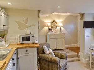 a kitchen with a chair and a microwave on a counter at The Old Cobblers Cottage in Bakewell