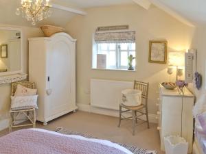 a bedroom with a bed and a table and chairs at The Old Cobblers Cottage in Bakewell