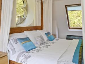 a bedroom with a white bed with blue pillows at St John The Baptist in Capel Curig