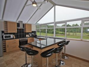 a kitchen with a counter with stools in it at Springfield Court - Lakeview in Bonvilston