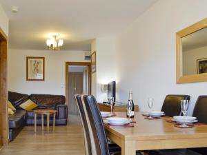 a dining room with a table and a couch at Springfield Court - Lakeview in Bonvilston
