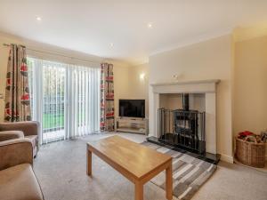 a living room with a coffee table and a tv at The Beeches in Sea Palling