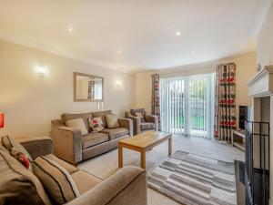 a living room with two couches and a table at The Beeches in Sea Palling