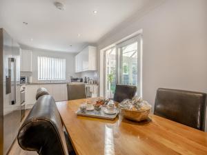 a kitchen with a wooden table with a bowl of food on it at The Beeches in Sea Palling +17 photos