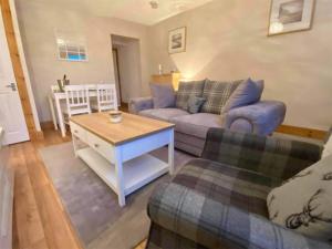 a living room with a couch and a table at Heather Cottage in Lauder