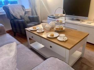 a living room with a coffee table with food on it at Heather Cottage in Lauder