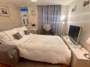 a bedroom with a bed and a desk with a television at Heather Cottage in Lauder