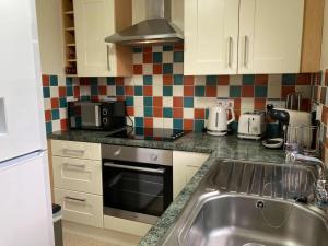 a kitchen with a sink and a microwave at Heather Cottage in Lauder +6 photos