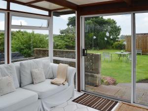 a living room with a white couch and sliding glass doors at The Willows Red Row in East Chevington