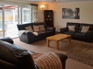a living room with leather couches and a coffee table at The Willows Red Row in East Chevington