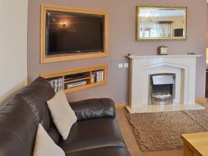 a living room with a couch and a fireplace at The Willows Red Row in East Chevington
