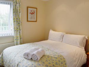 a bedroom with two towels on a bed at The Willows Red Row in East Chevington +8 photos