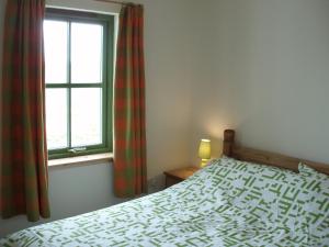 a bedroom with a bed and a window at Taigh Uaine in Culkein