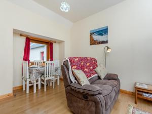 a living room with a couch and a table at The Stable Mey in Scarfskerry