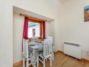 a dining room with a table and chairs and a window at The Stable Mey in Scarfskerry
