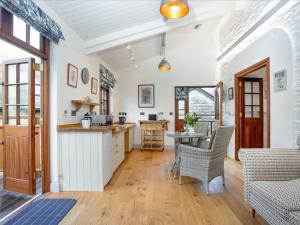 a kitchen with white walls and a table and chairs at Mill Balcony in Ashsprington