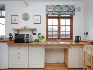 a kitchen with a sink and a microwave at Mill Balcony in Ashsprington