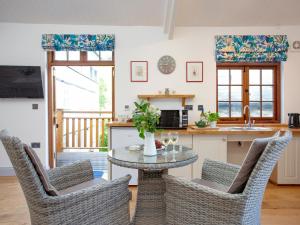 a kitchen and dining room with a table and chairs at Mill Balcony in Ashsprington
