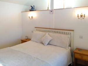 a bedroom with a white bed with two pillows at Tawmans in Kilmuir
