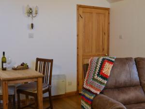 a living room with a couch and a table at Tawmans in Kilmuir