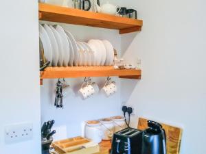 a kitchen with plates and cups on a shelf at Tawmans in Kilmuir