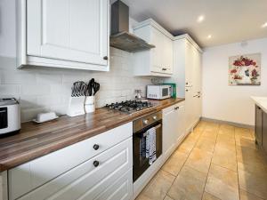a kitchen with white cabinets and a stove top oven at Return Again in Beaumaris