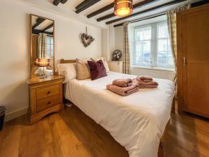a bedroom with a bed with towels on it at Return Again in Beaumaris