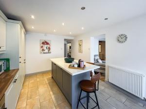 a kitchen with a counter and a bar with a stool at Return Again in Beaumaris