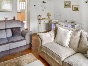 a living room with a couch and a chair at Newbiggin Cottage in Richmond