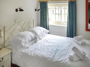 a bedroom with a white bed with towels on it at Newbiggin Cottage in Richmond