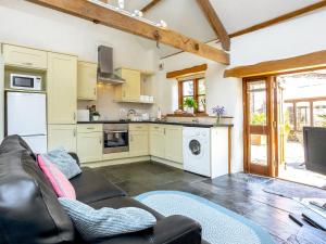 a living room with a couch and a kitchen at Old Dairy in Chulmleigh