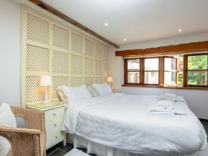 a bedroom with a large white bed and a window at Old Dairy in Chulmleigh