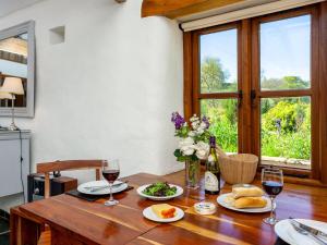 a wooden table with two glasses of wine and food at Old Dairy in Chulmleigh