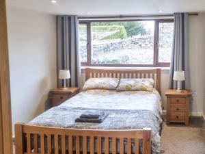 a bedroom with a bed and a large window at Yr Hen Weithdy in Llanllechid