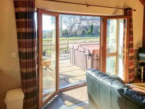 a living room with a sliding glass door to a patio at Yr Hen Weithdy in Llanllechid