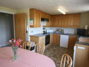 a kitchen with a table with a vase of flowers on it at Halliday Hill Cottage in Dalton