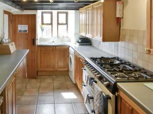 a kitchen with a stove and a sink at Bellypig Cottage in Bellerby