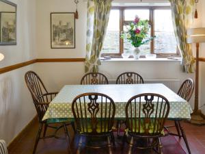 a dining room with a table and chairs and a window at Bellypig Cottage in Bellerby
