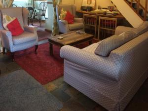 a living room with two chairs and a coffee table at Bellypig Cottage in Bellerby