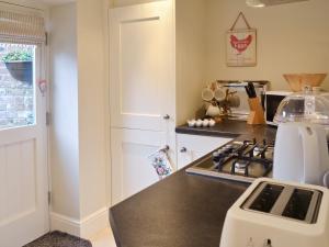 a kitchen with a stove and a counter top at Mill Race Cottage in Bakewell